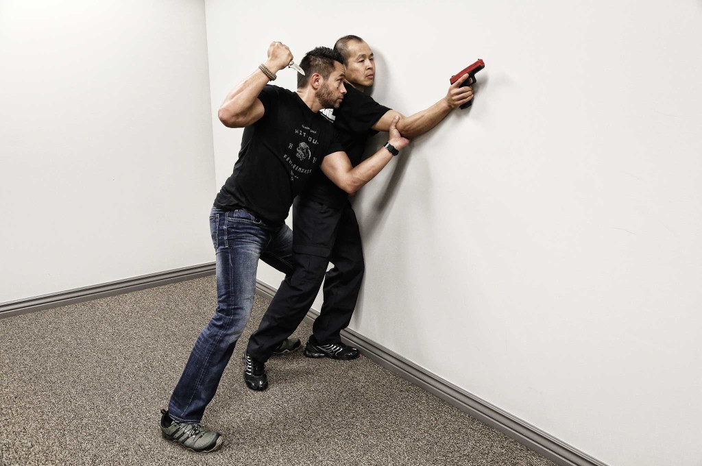 Jared Wighongi (left) steps to the Outside Line while parrying. In a dominant position, he slams the bad guy against the wall, pins the gun, and transitions to his Browning Vanquish Pocket Deploy knife. 