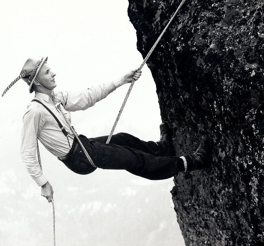A vintage photo shows a climber using the Dülfersitz method.
